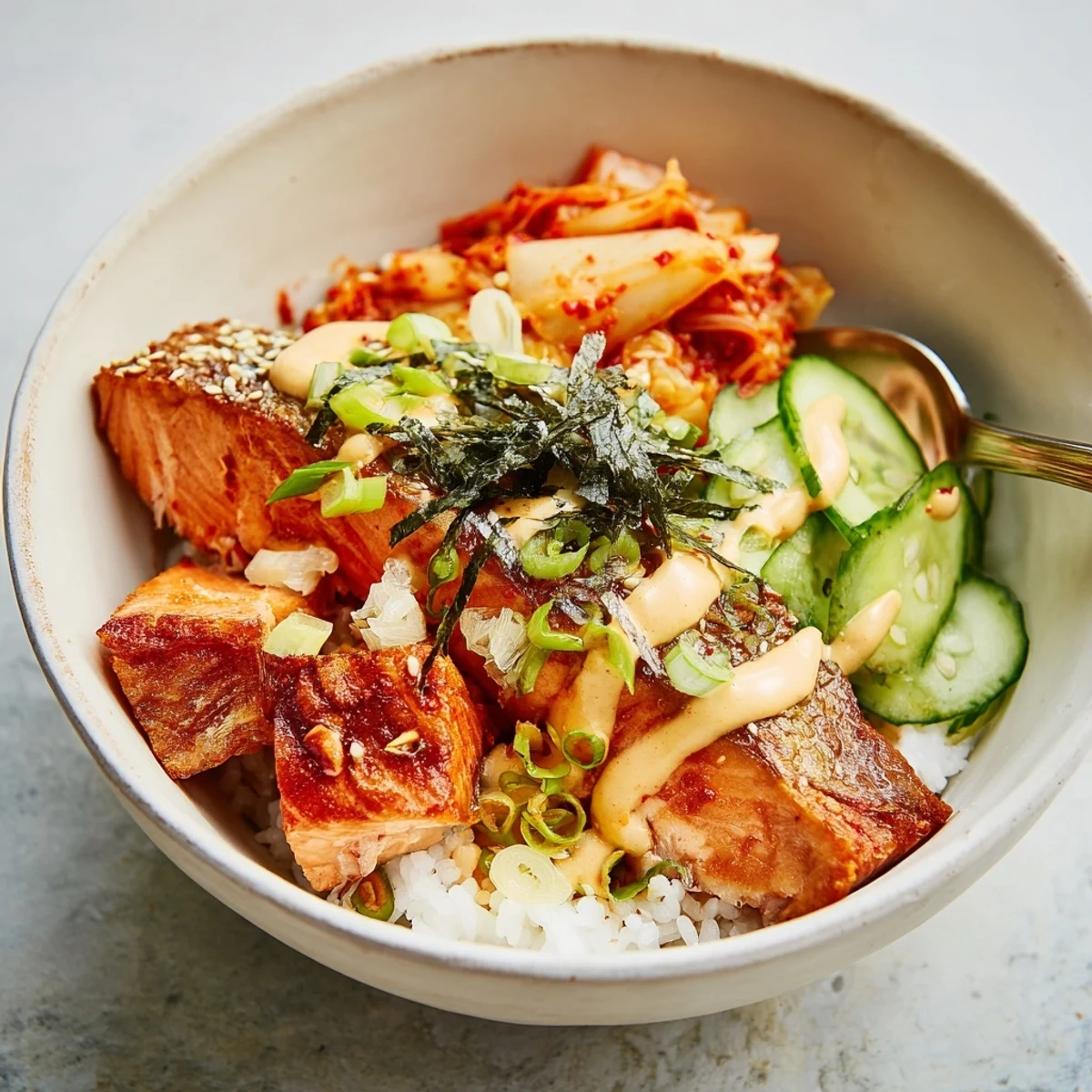 Delicious crispy salmon rice bowl topped with spicy mayo, fresh avocado, and kimchi.  