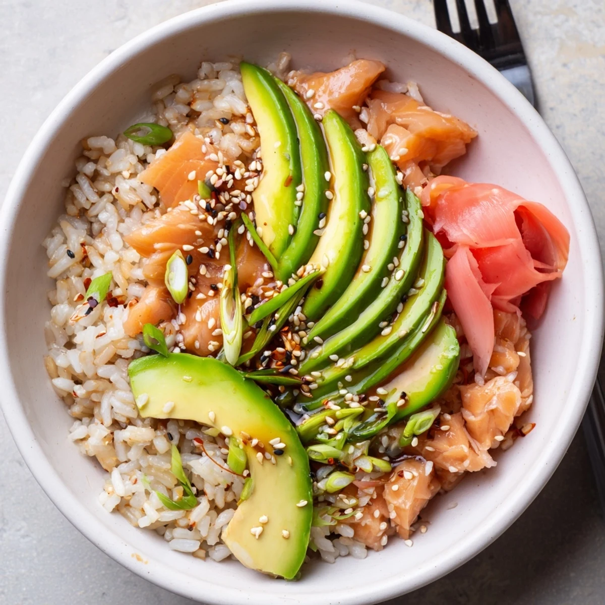 Delicious leftover salmon and rice bowl, topped with fresh avocado and cucumber slices.  