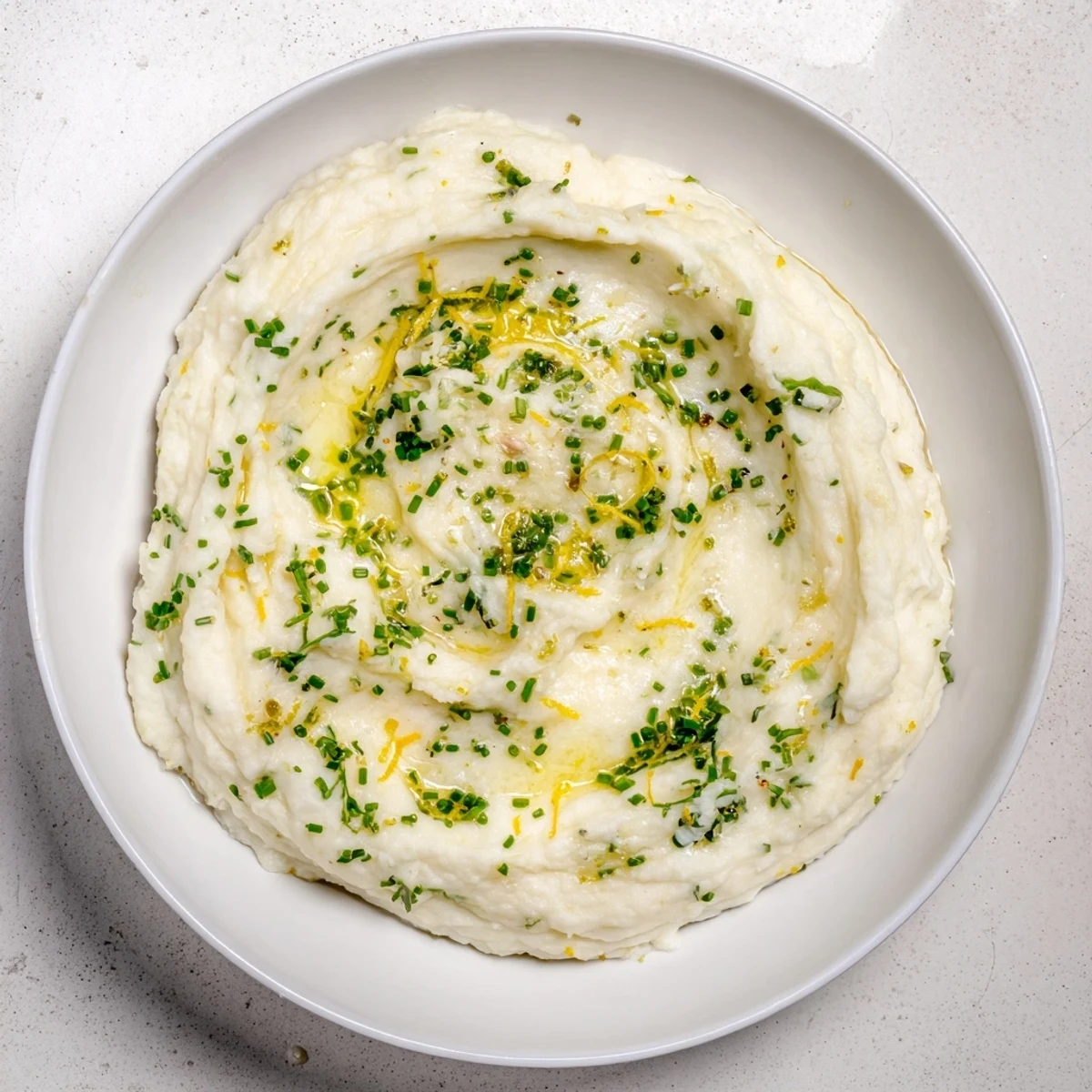 Creamy cauliflower mash with garlic and lemon, a vibrant vegetarian side dish ready to eat.