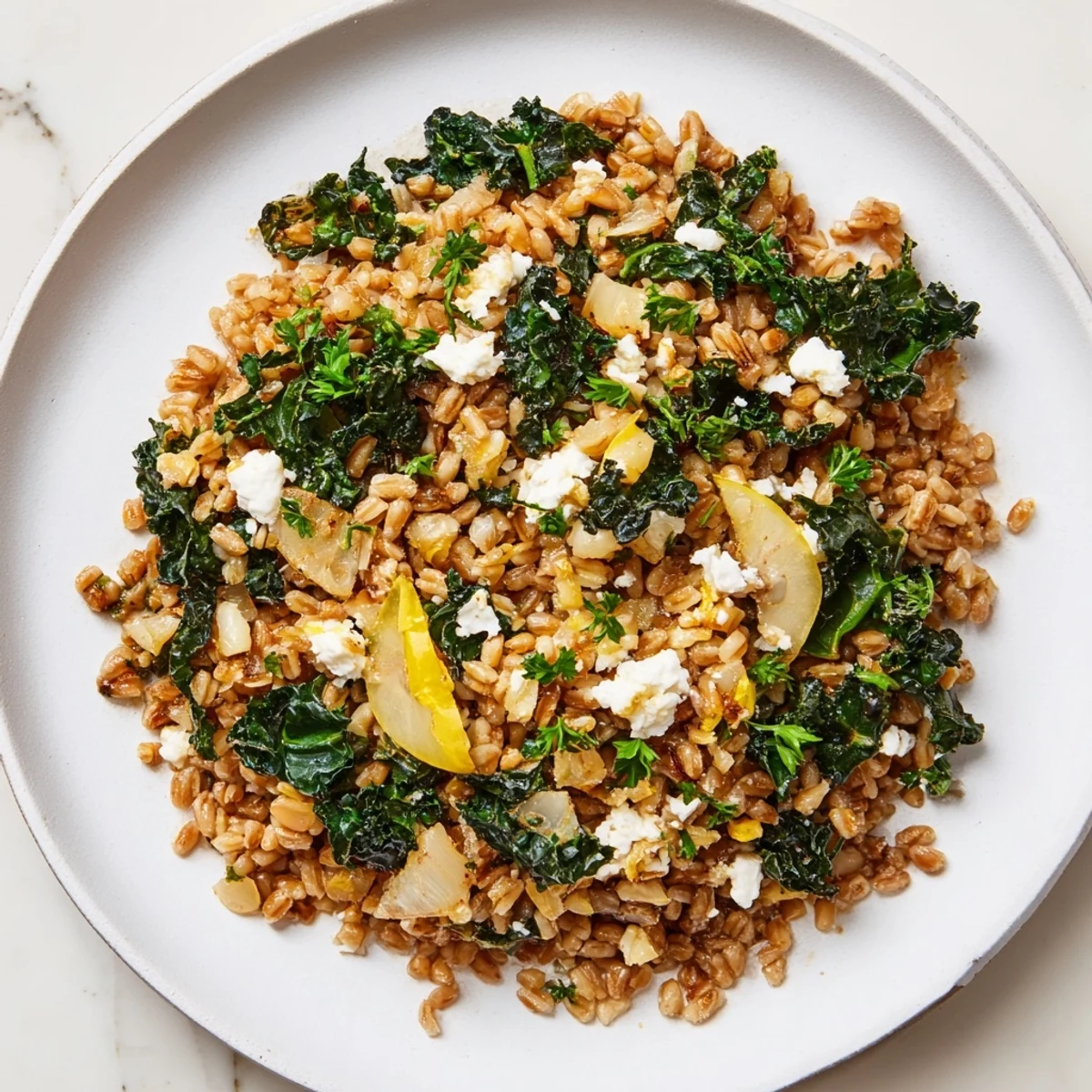 A vibrant bowl of warm Farro & Greens Pilaf topped with toasted almonds and feta.