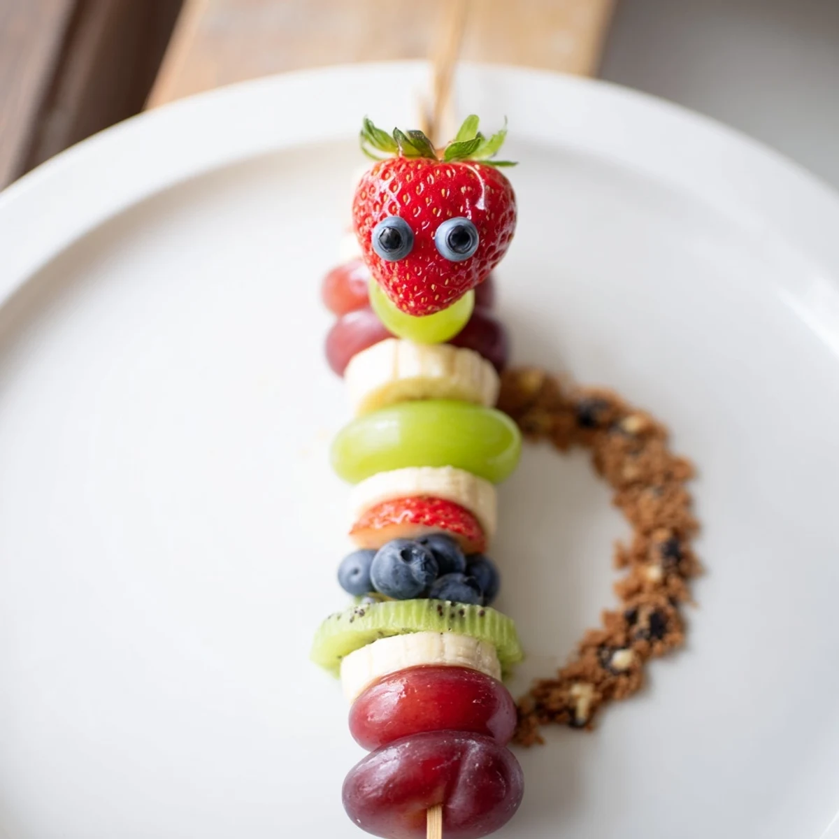 Freshly made Caterpillar Fruit Skewer Track, featuring bright fruit skewers arranged on a chocolatey cookie track.