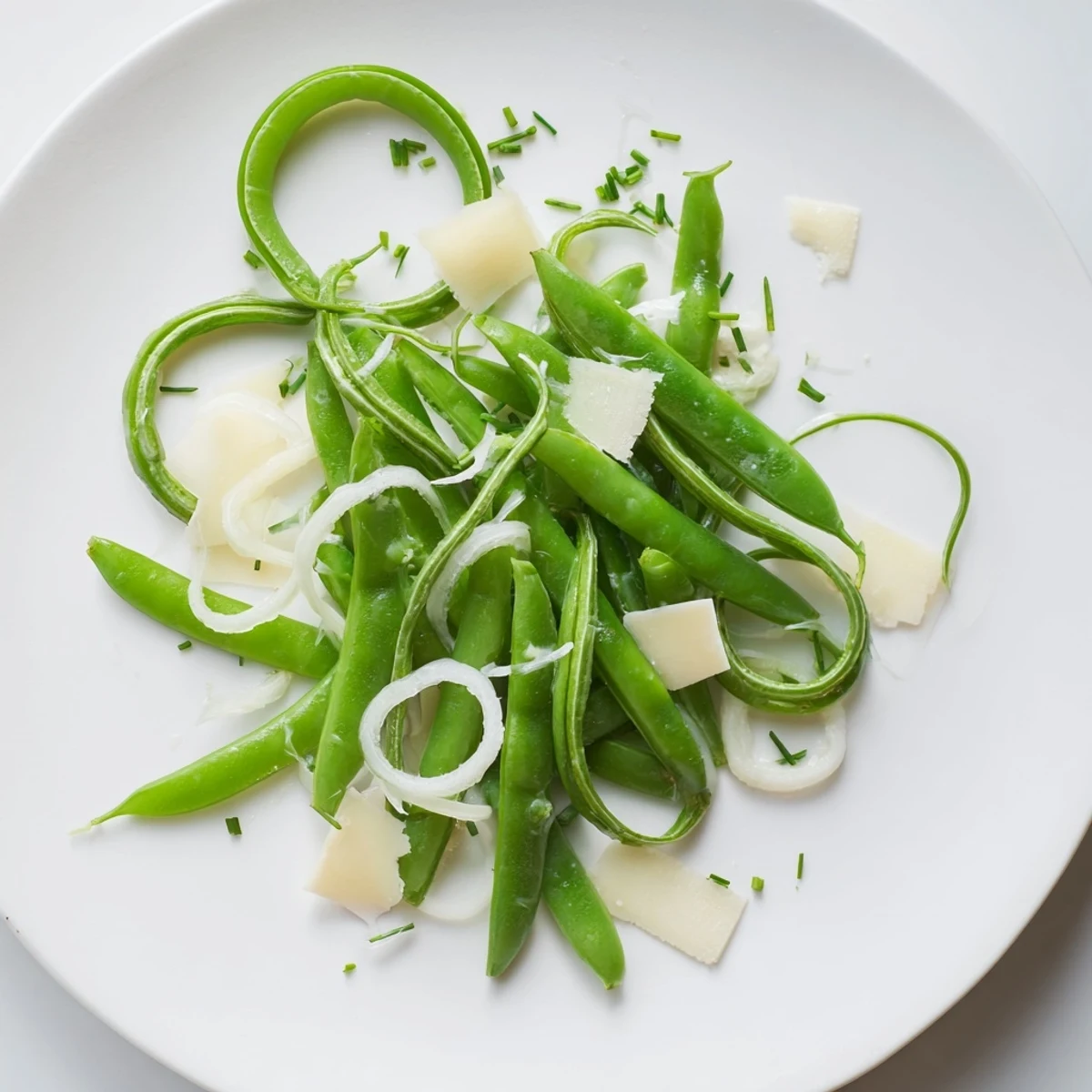 A flavorful English Ivy salad, with vibrant green snap peas and cheddar cheese crumbles.