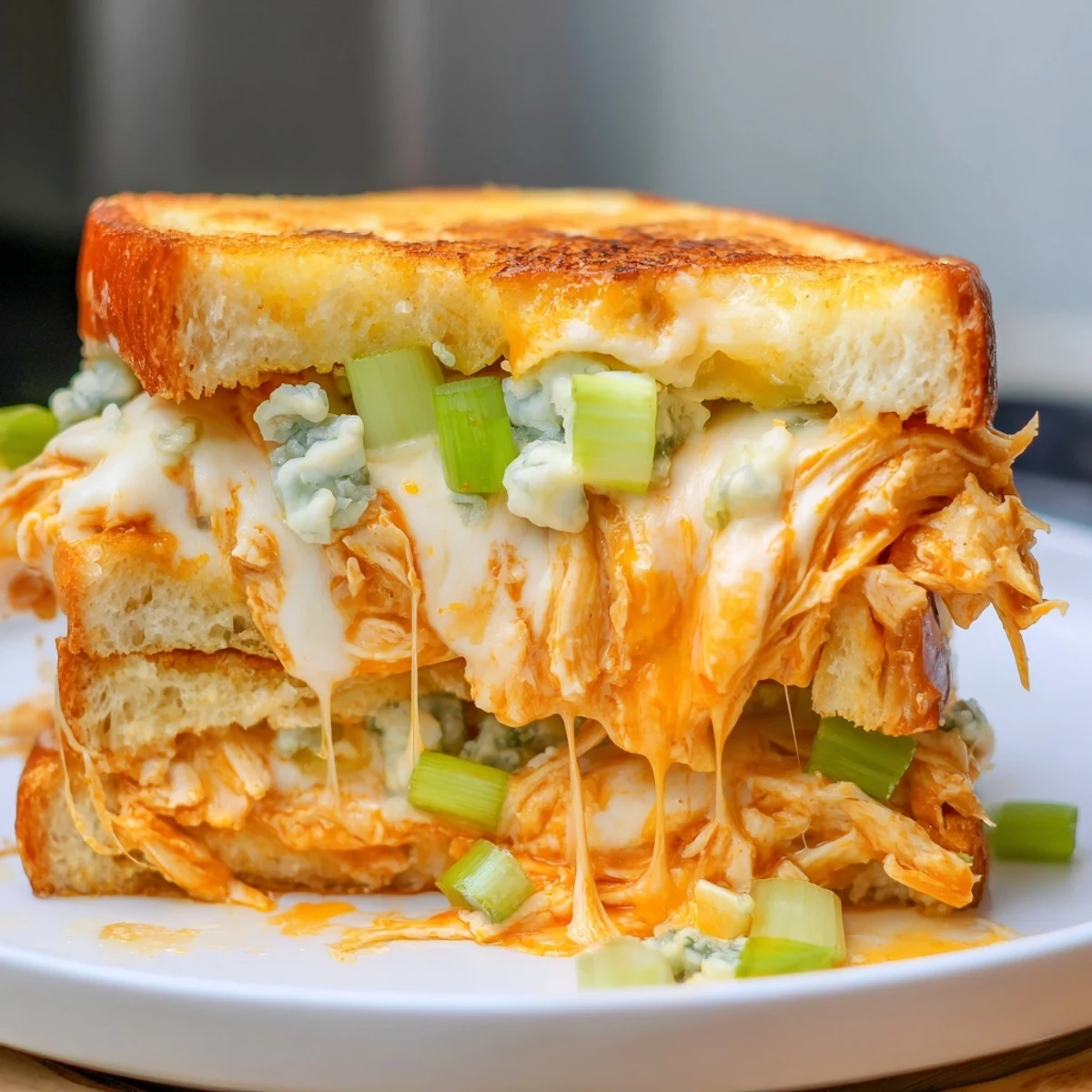 Crispy sourdough cradles spicy buffalo chicken and creamy cheeses in this grilled cheese sandwich recipe.