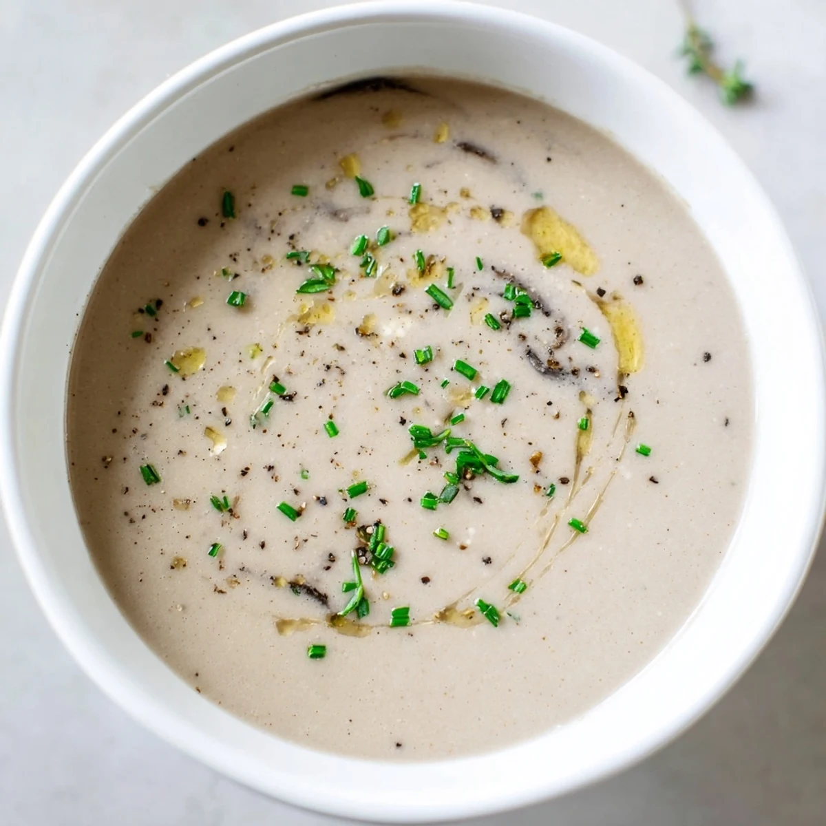 A steaming bowl of Creamy Mushroom Bisque, garnished with fresh herbs, ready to savor.