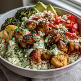 Colorful vegetable mix on cauliflower rice bowl with cherry tomatoes and herbs.