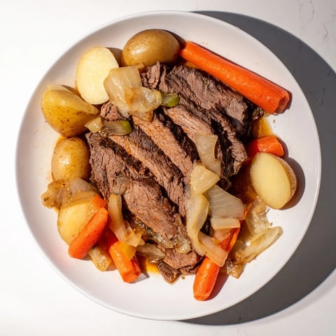 Fork-tender pickle brine pot roast, served with tender potatoes and savory vegetables, ready to enjoy.