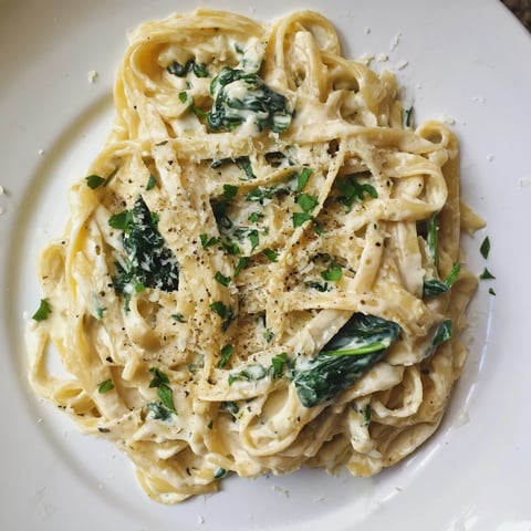 Creamy Greek Yogurt Spinach Alfredo Pasta with vibrant green spinach and grated Parmesan cheese, ready to serve.
