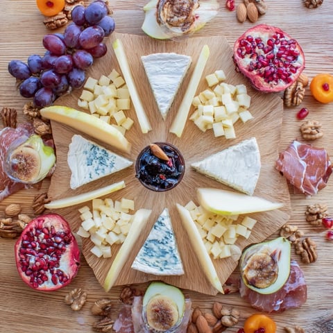 Éclat d’Étoiles Planche de Noël: A starburst charcuterie board with cheeses, meats, fruit, and nuts, ready to serve!