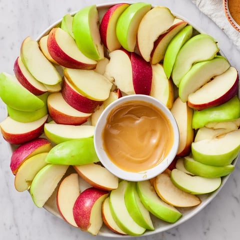 Crisp apple slices artfully surround a luscious, homemade caramel dip, a perfect Apple Slices appetizer.