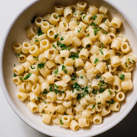 Golden, steaming bowl of one-pot garlic butter ditalini pasta, garnished with fresh parsley and cheese.
