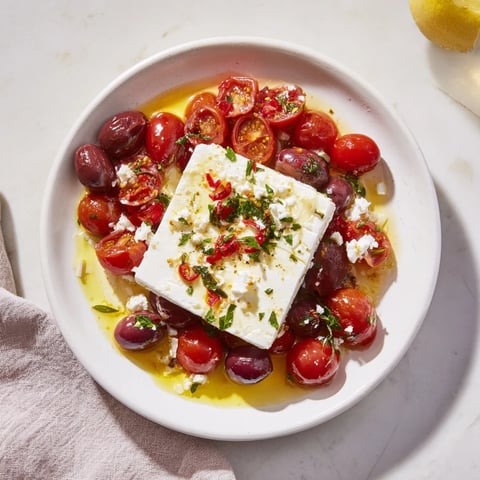 Golden baked feta 2.0 with roasted tomatoes, honey glaze, and chili flakes, a vibrant vegetarian pasta.