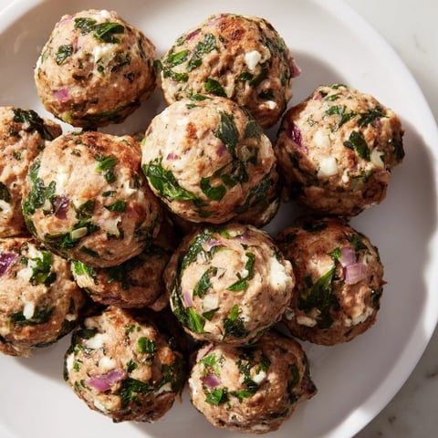 Golden-brown Spinach Feta Turkey Meatballs, tender and juicy, ready to savor warm with fresh herbs.