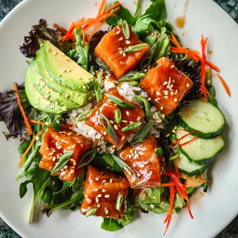 Fresh salmon Poke Bowl Salad, glistening with a vibrant soy-ginger marinade and sesame seeds.