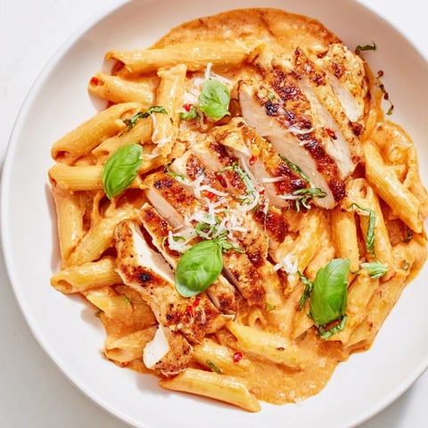 Creamy Tomato Basil Chicken Pasta with fresh basil garnish, a comforting Italian meal.