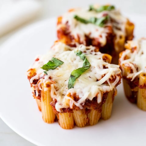 Golden, bubbly Baked Ziti Cups just out of the oven, with melted mozzarella and tomato sauce.
