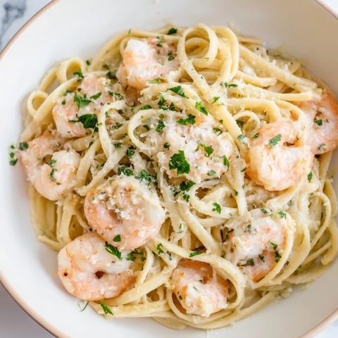 Creamy Garlic Shrimp Pasta twirls al dente linguine coated in a luscious garlic cream sauce, flecked with fresh parsley and tender pink shrimp.