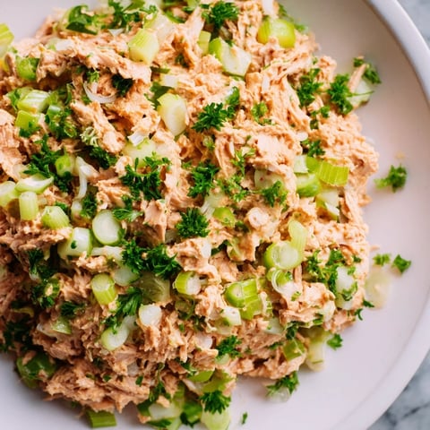 A close-up of the Spicy Zesty Tuna Salad, featuring flaked tuna tossed in creamy sriracha mayo with crisp scallions and celery.