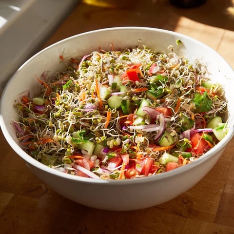 Vibrant Sprouted Seed Salad in a white ceramic bowl, showcasing fresh mung bean, alfalfa, and radish sprouts mixed with colorful diced vegetables.