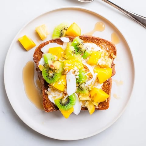 Golden-baked yogurt-custard toast with mango and kiwi for a vibrant brunch treat.  