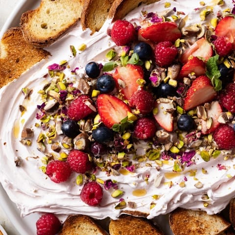 Colorful butter board dessert featuring whipped cream cheese and sweet chocolate chips.  