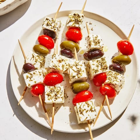 Vibrant skewers showcasing salty feta and olives, drizzled with olive oil, perfect for Holiday Cheers.