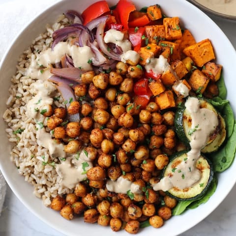 This Roasted Chickpea Buddha Bowl showcases perfectly roasted vegetables, golden chickpeas, and a creamy tahini drizzle.