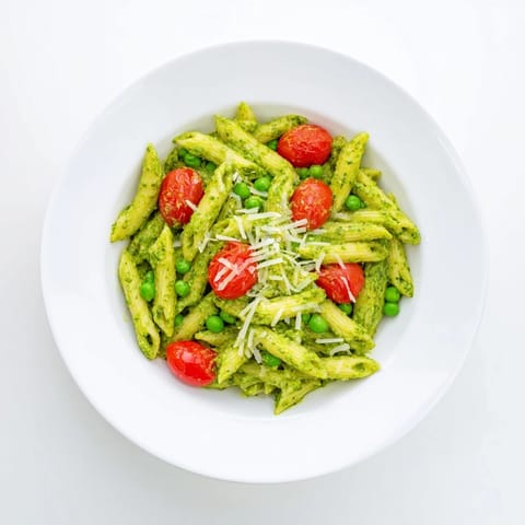 Tossing al dente pasta with vibrant basil pesto, sweet peas, and juicy cherry tomatoes for an easy, vegetarian picnic side.