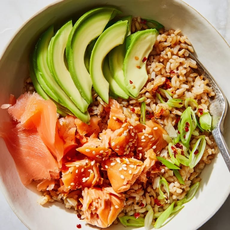Colorful leftover salmon and rice bowl drizzled with soy sauce and sesame oil.  