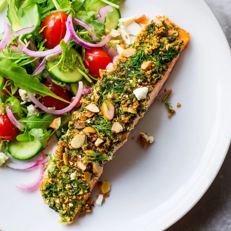 Perfectly cooked herb-crusted salmon salad, showcasing tender fish and a refreshing mix of greens.
