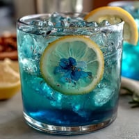 Refreshing butterfly pea flower color-change lemonade with vibrant blue hue and citrus twist.
